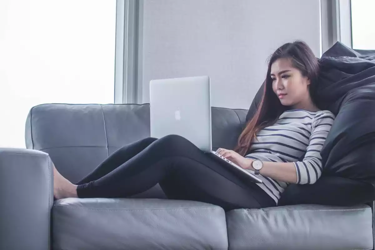 Chica con ordenador en sofá