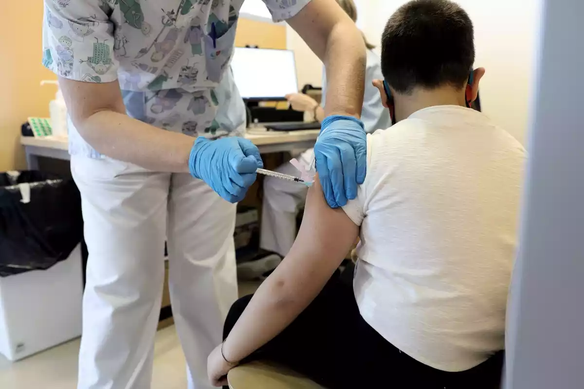 Un trabajador sanitario inyecta la vacuna contra el Covid-19 a un menor, en el Hospital Infanta Sofía