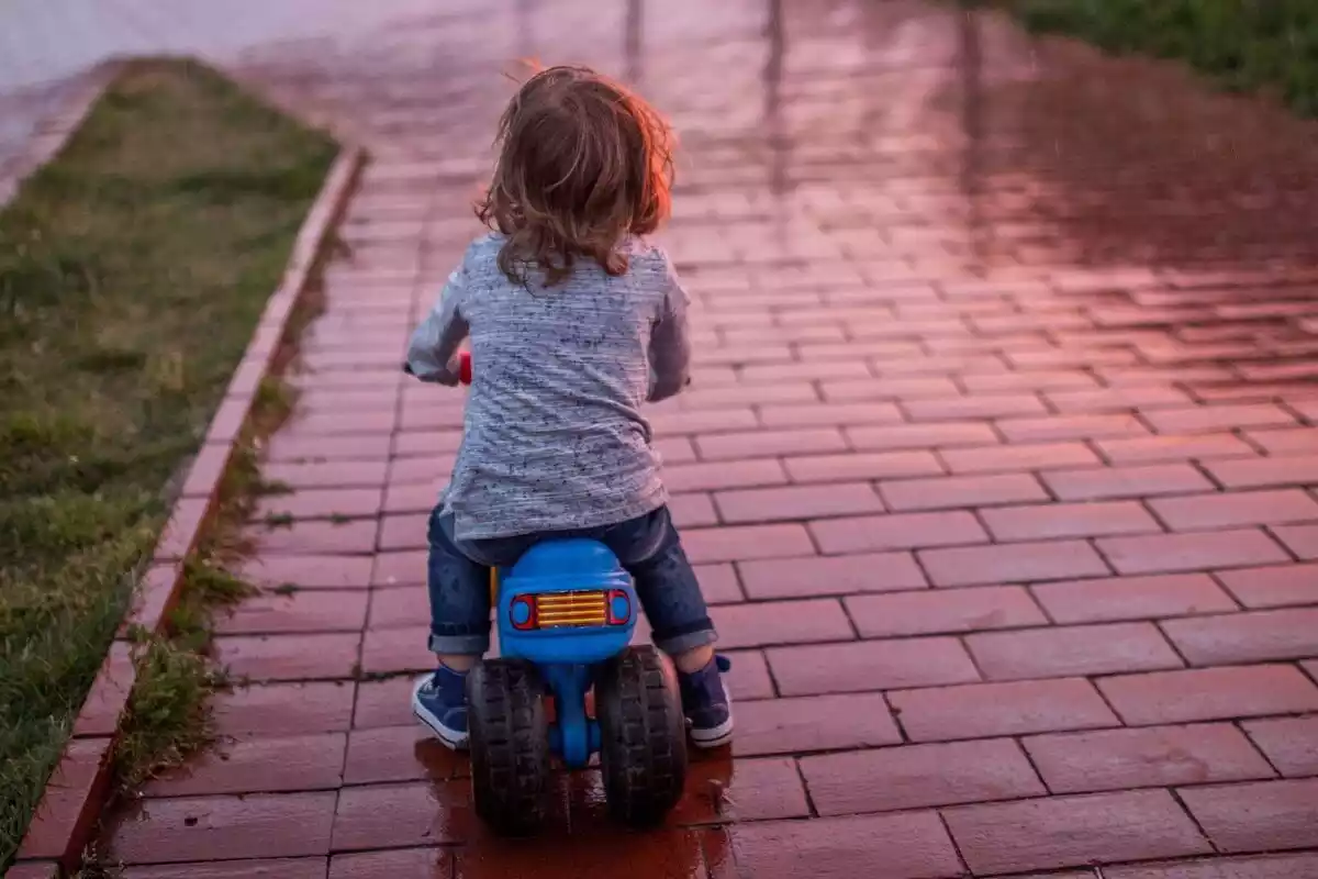 Foto de un niño subido en una moto de juguete