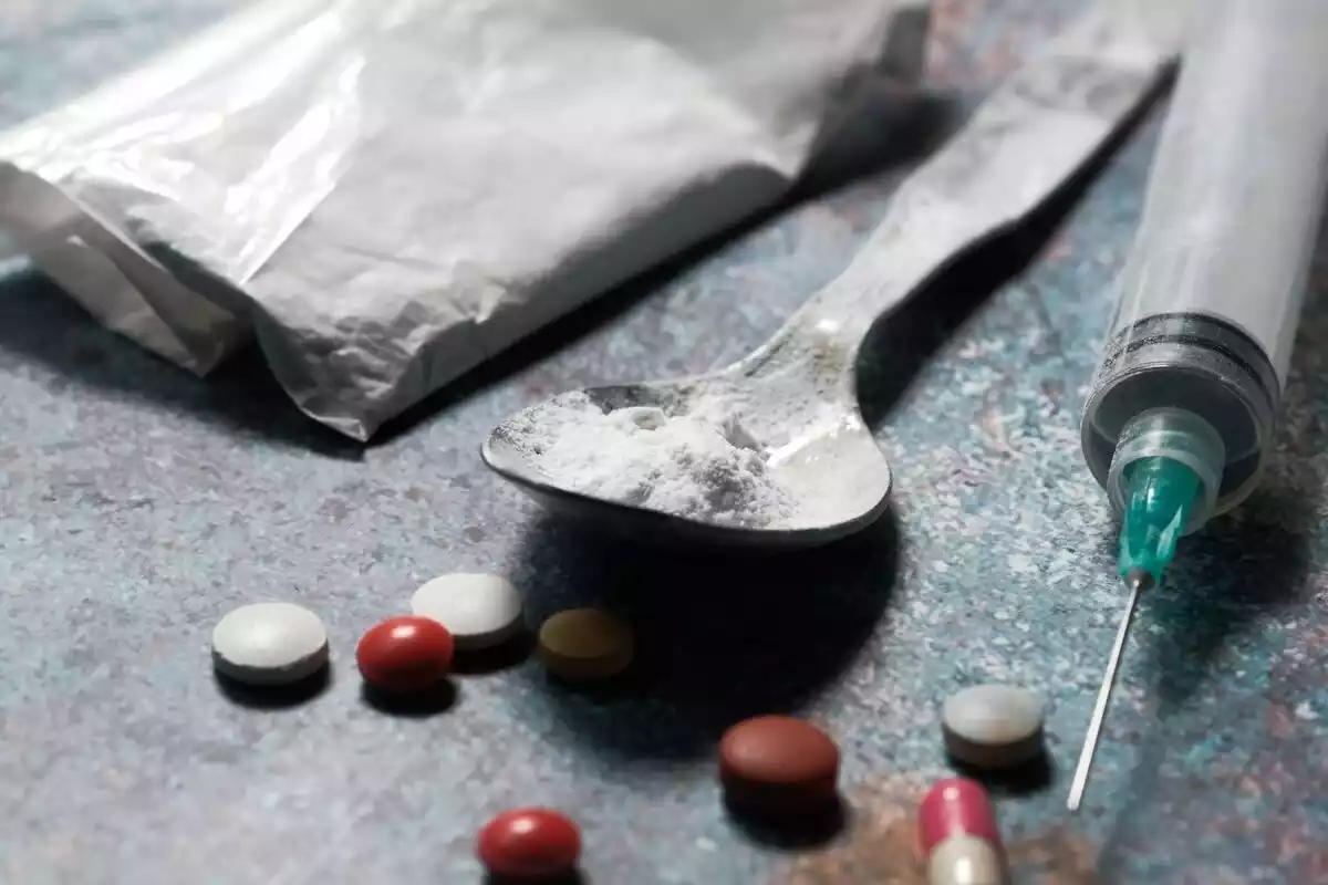 Imagen de droga, unas pastillas y una jeringilla.