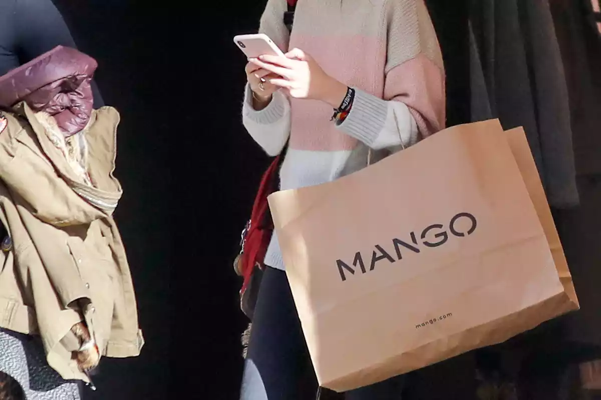 Chica paseando con una bolsa de Mango colgada del brazo