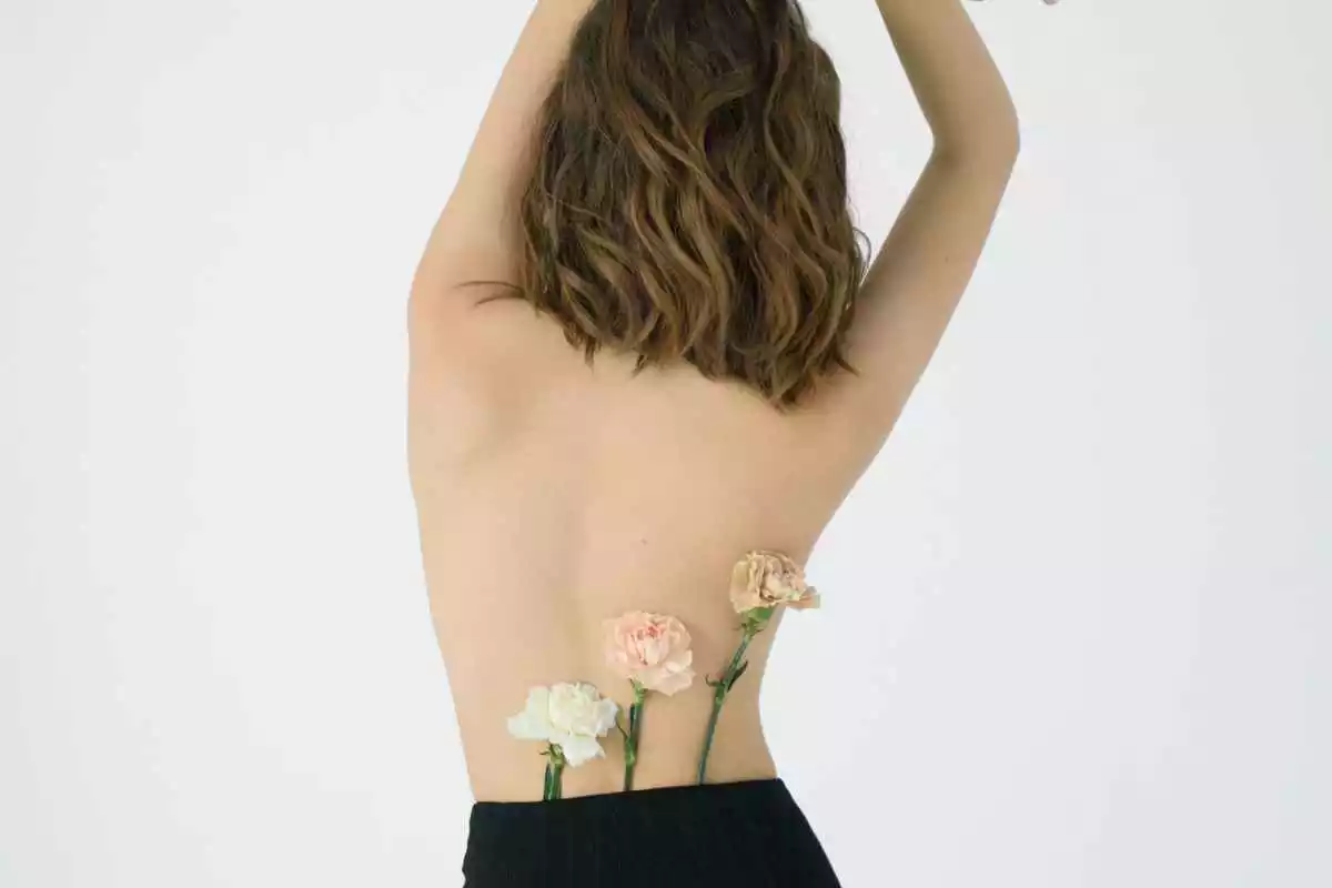 Fotografia de la espalda de una mujer con unas rosas