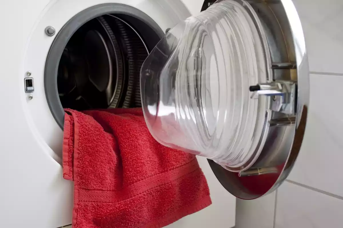 Primer plano de una lavadora abierta con una toalla roja