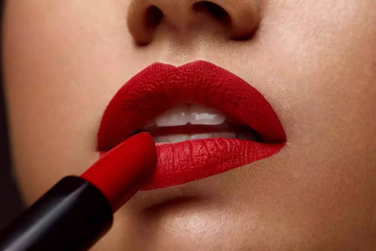 Imagen de archivo de una mujer que se está pintando los labios