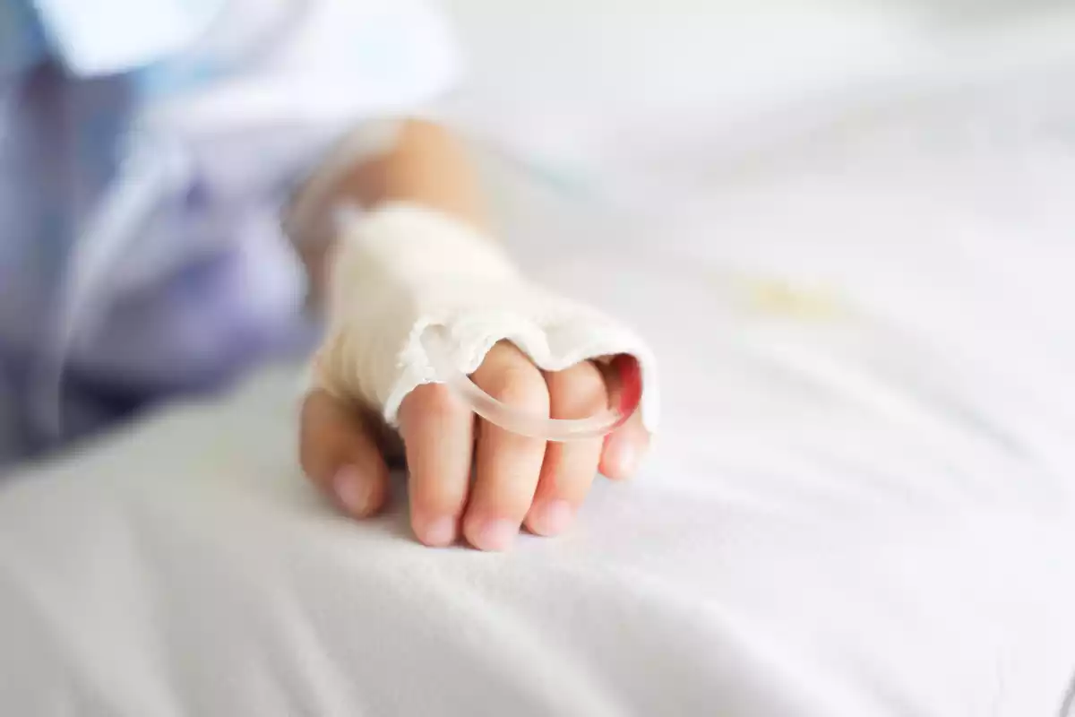 La mano de un niño con una intravenosa
