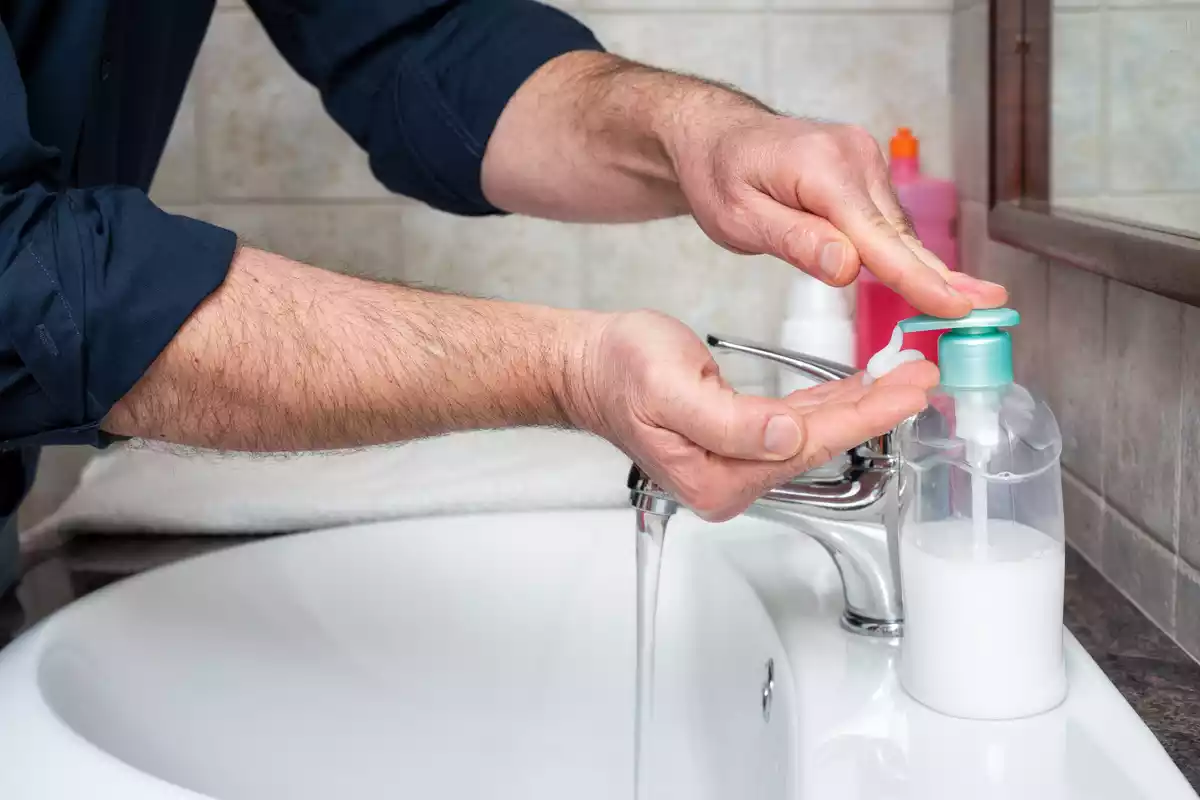 Un hombre se lava las manos con jabón