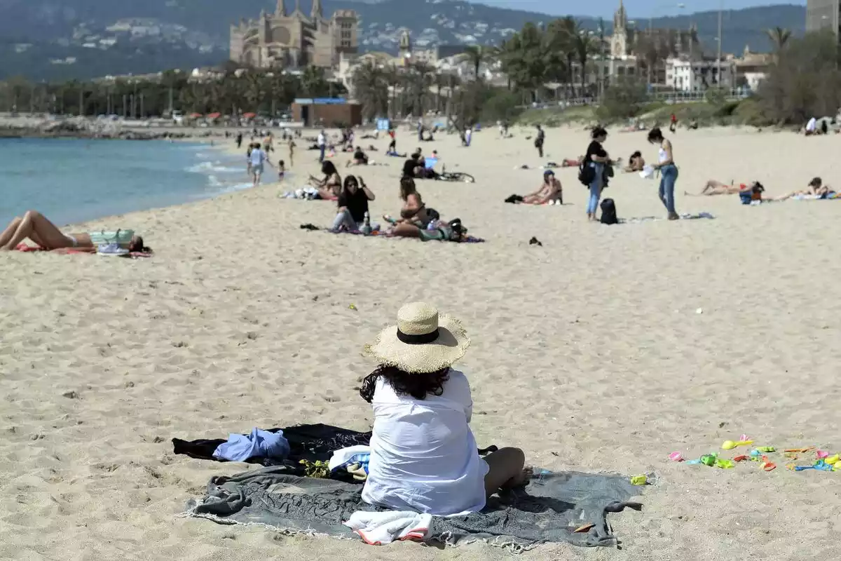 Personas en una playa de Mallorca con mascarillas en marzo de 2021