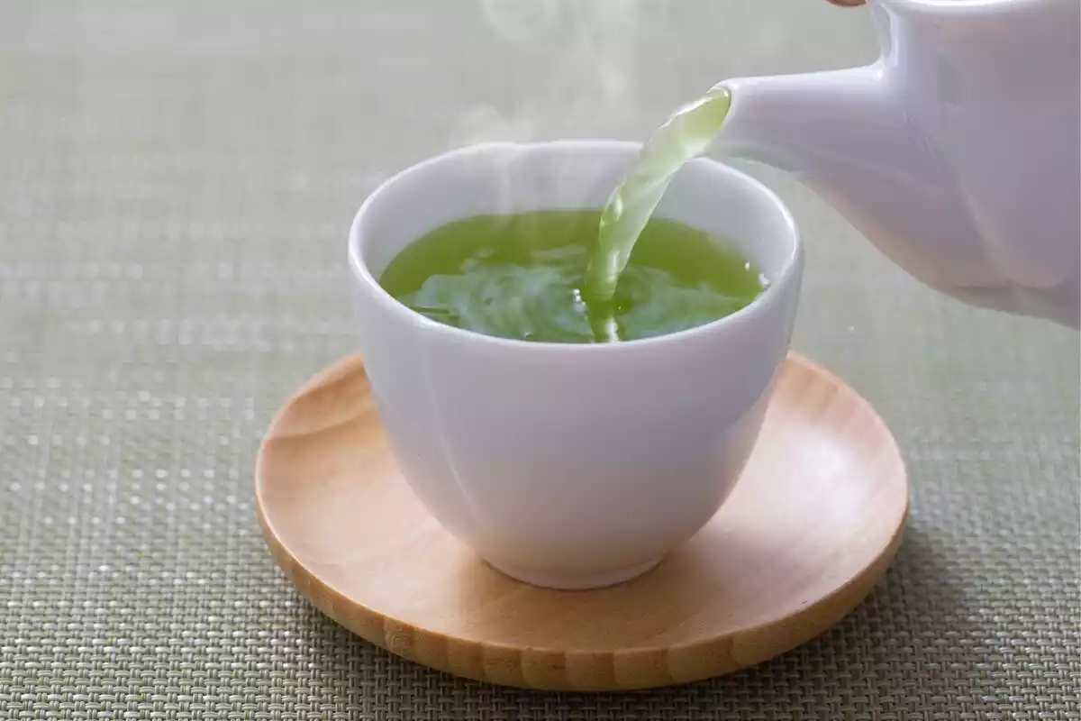 Una taza de té verde caliente con vapor saliendo