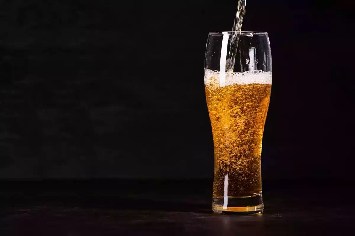 Foto de un vaso transparente lleno de cerveza