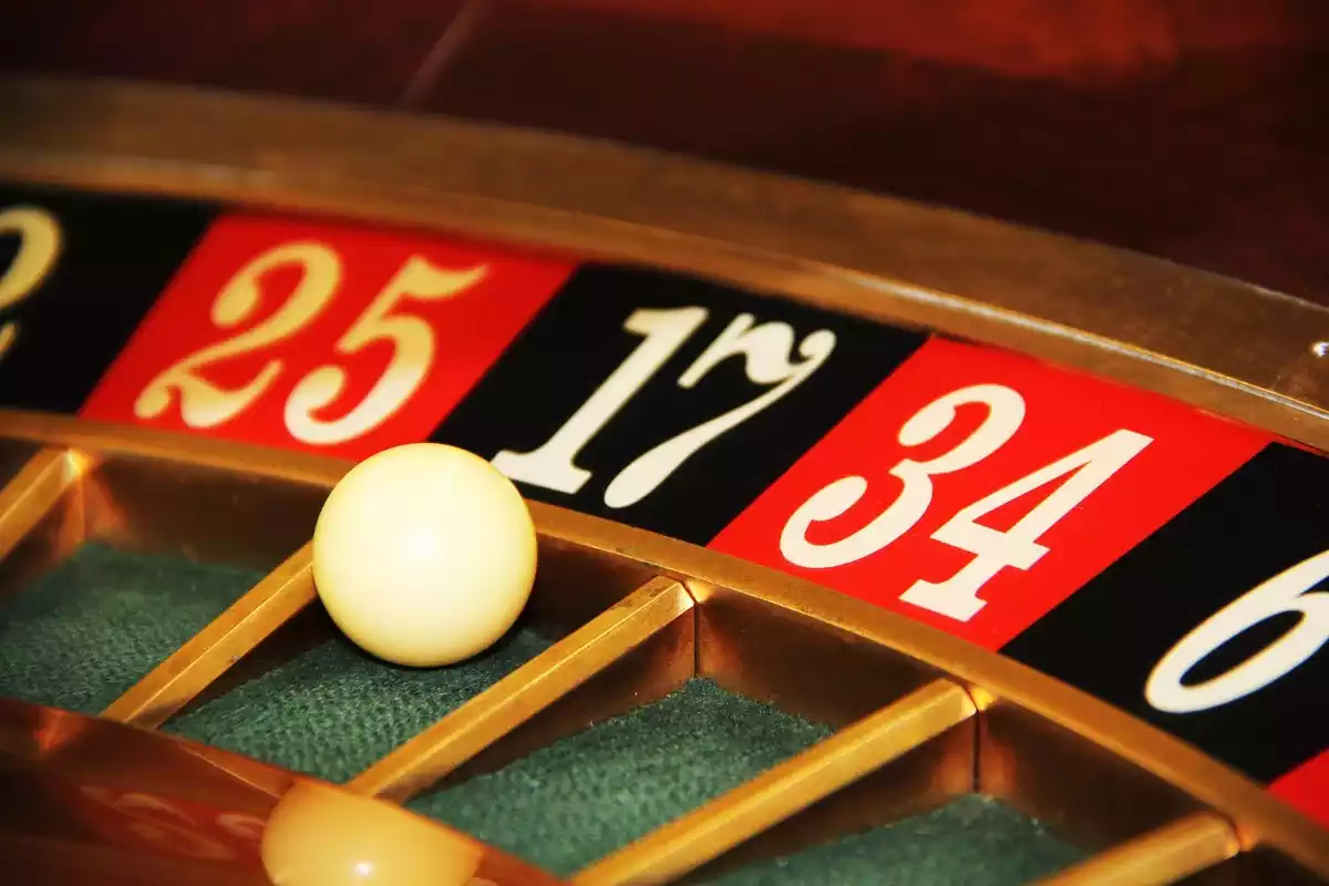 Primer plano de una ruleta de casino con la pelota situada en el número 17