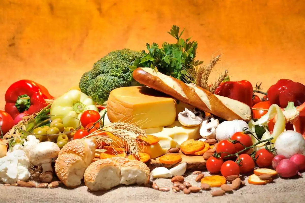 Un montón de alimentos: pan, brócoli, queso, pimientos, tomates, champiñones