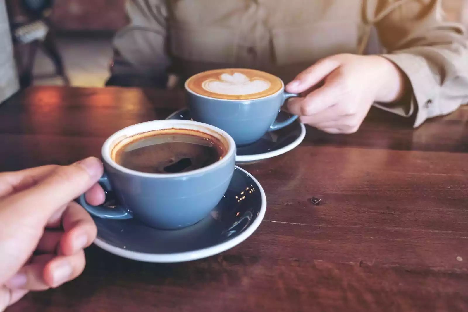 Dos tazas de café con leche y mesa de madera art cafe