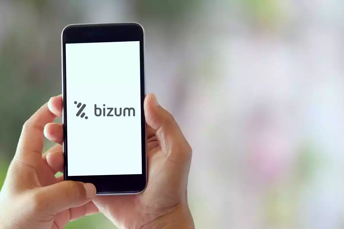 Unas manos sujetando un teléfono móvil que tiene la aplicación de Bizum abierta