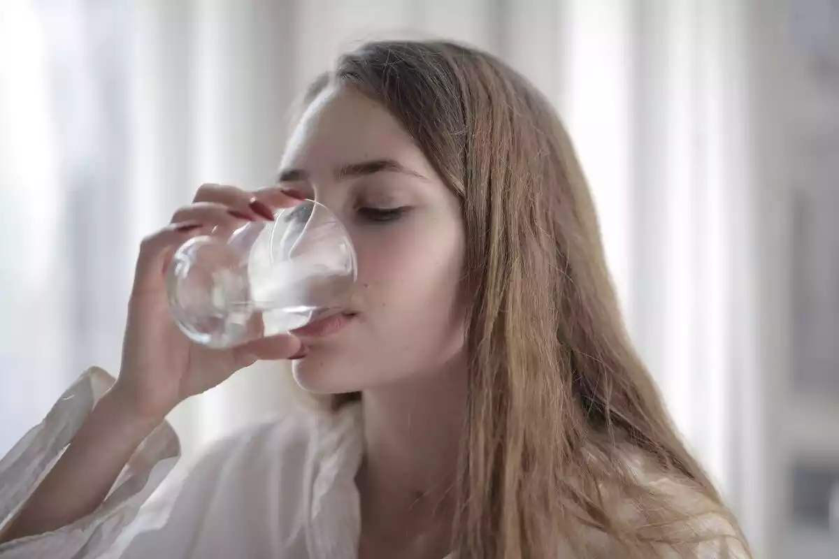 Chica bebiendo un vaso de agua
