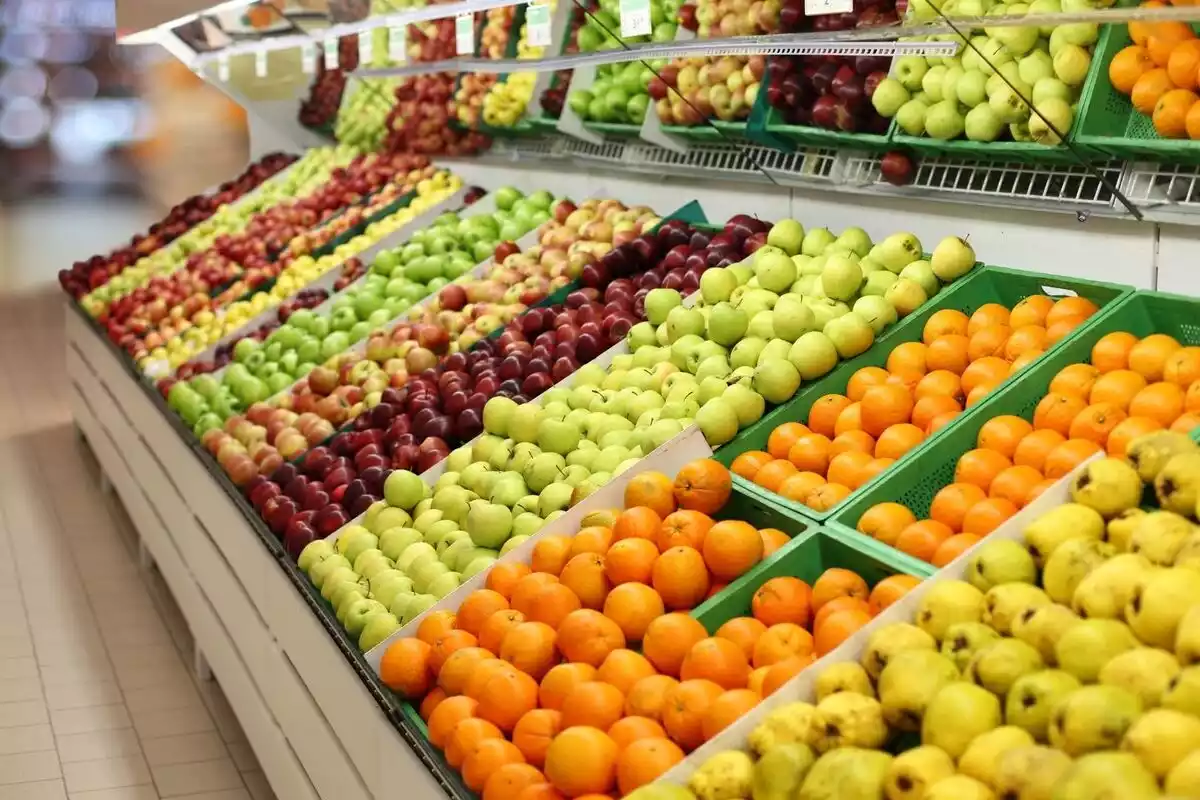 Naranjas, manzanas, peras y muchas otras frutas en un supermercado
