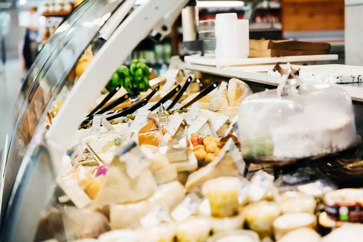 Nevera llena de quesos en un supermercado