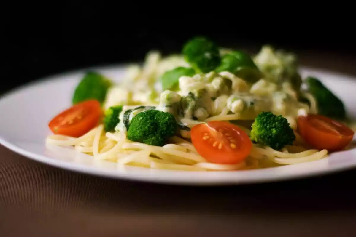 Plato de pasta con brócoli, queso y tomates