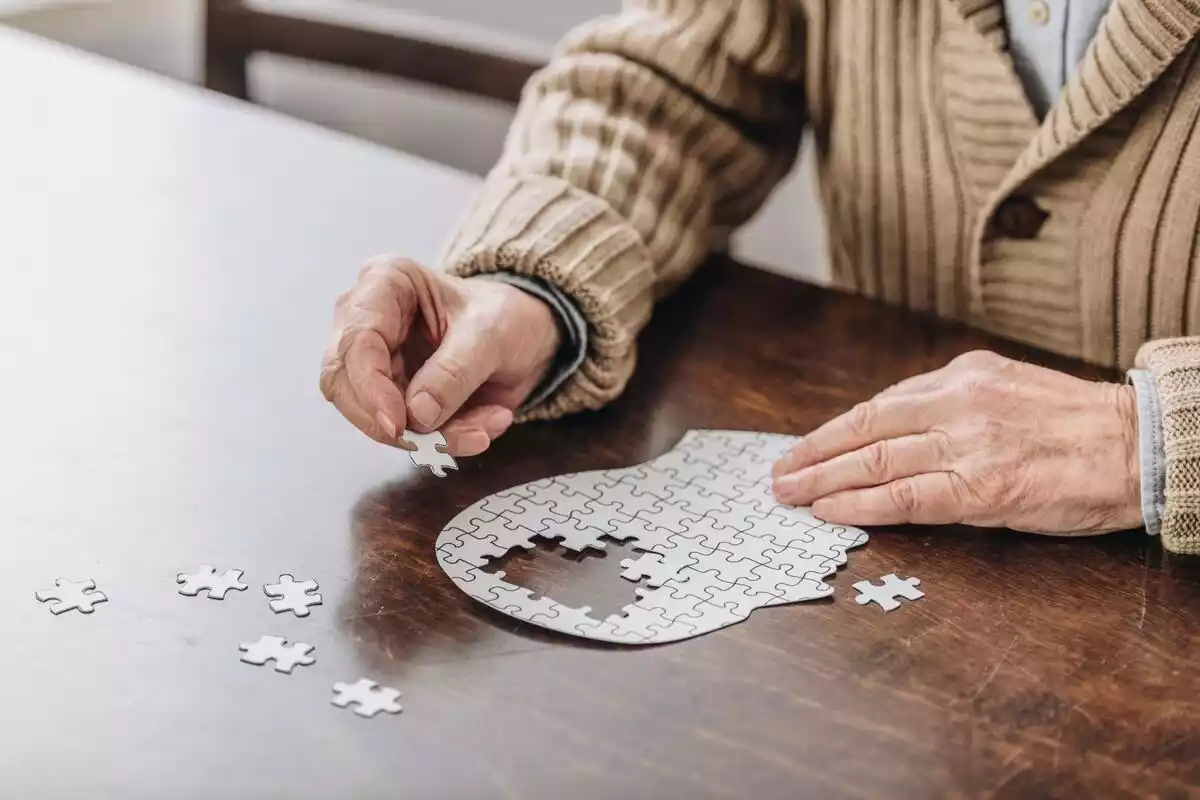 Un anciano intenta construir un puzzle