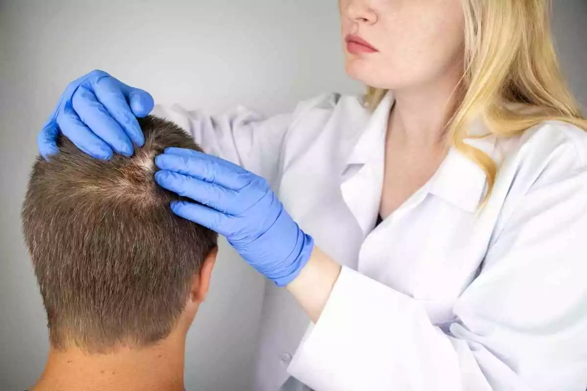 Una dermatóloga revisando el cuero cabello