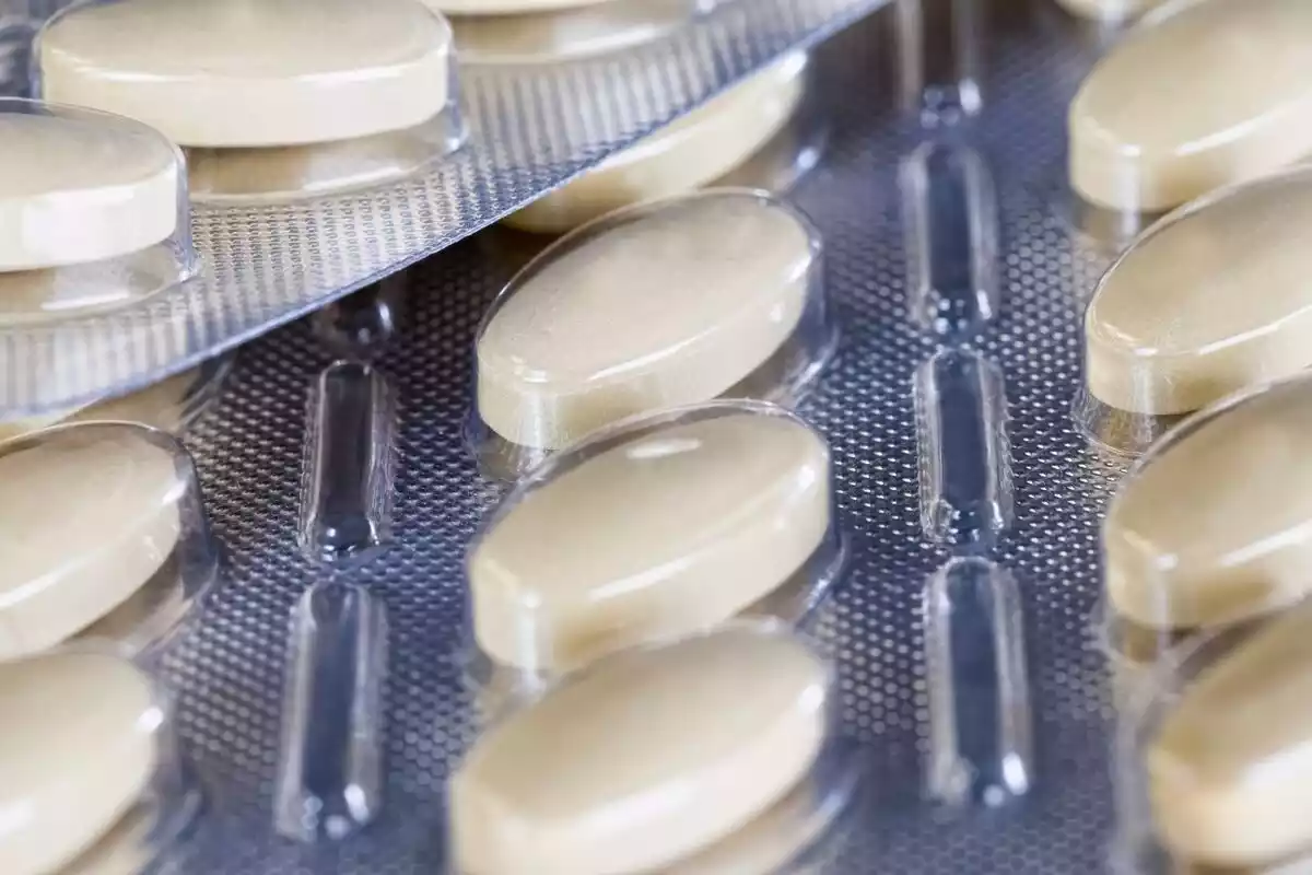 Varias pastillas blancas en un blíster de medicamentos
