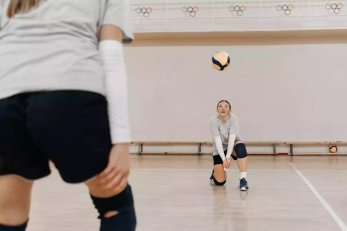 Dos chicas jugando al volleyball en una pista