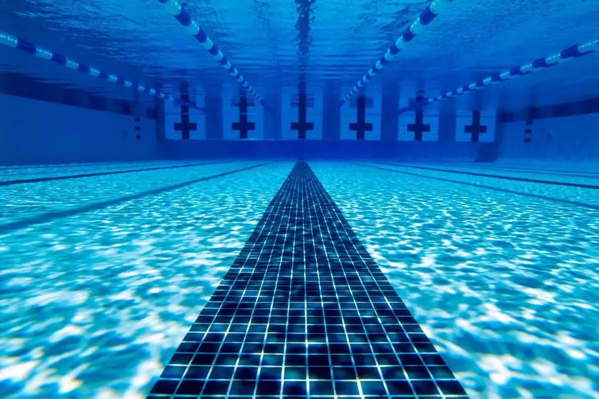 Fondo azul de una piscina con carriles para natación