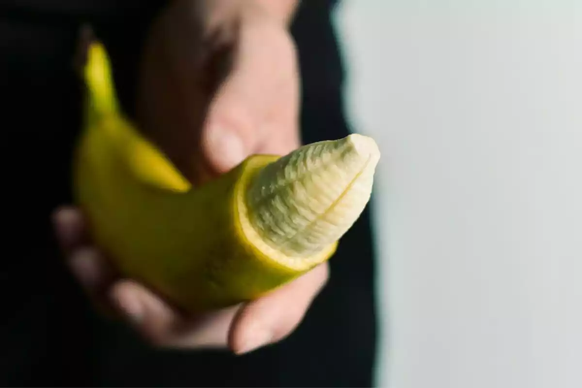 Hombre sosteniendo un plátano simulando que es un pene