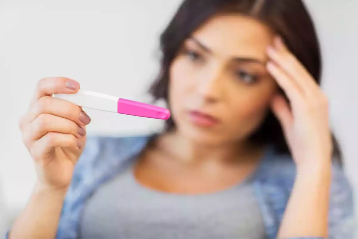 Mujer mirando con preocupación el resultado de un test de embarazo