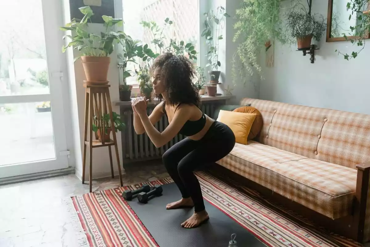 Mujer practicando ejercicio mientras hace una sentadilla
