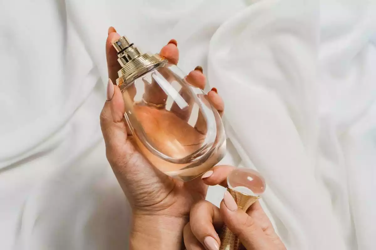 Primer plano de un perfume en las manos