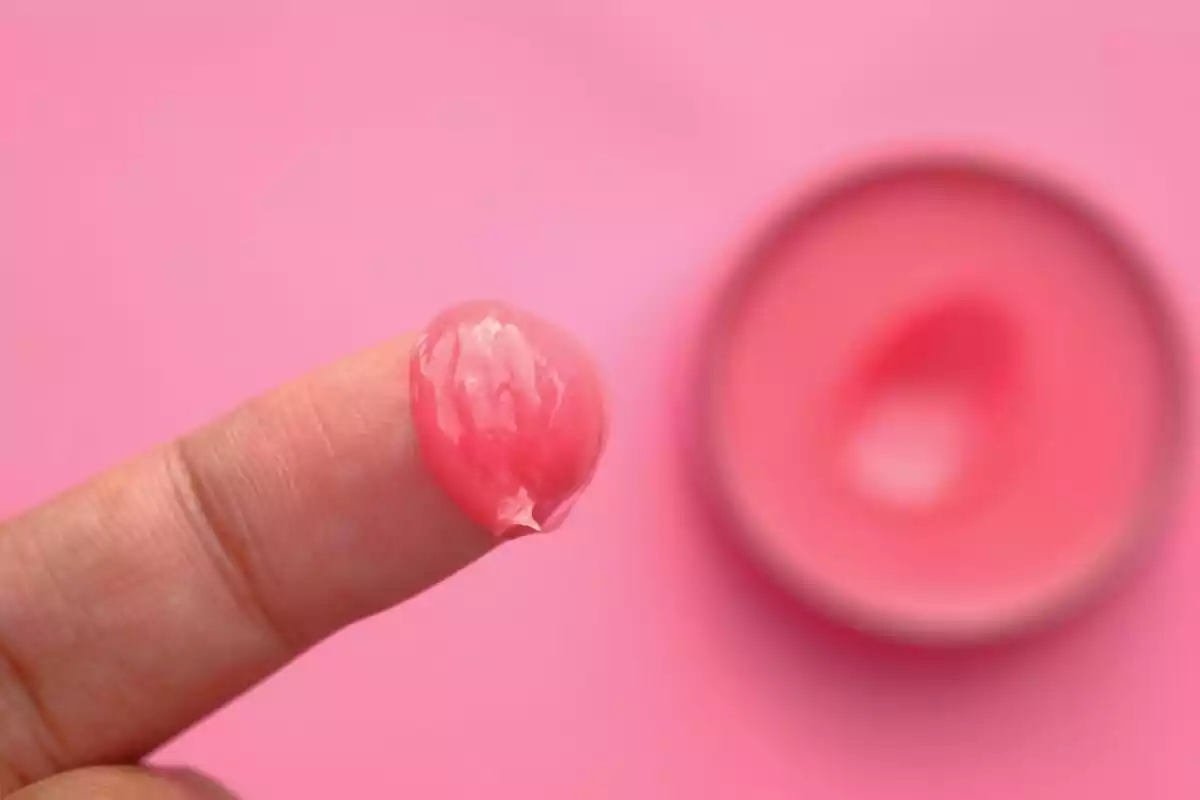 Un dedo con una pizca de vaselina rosa