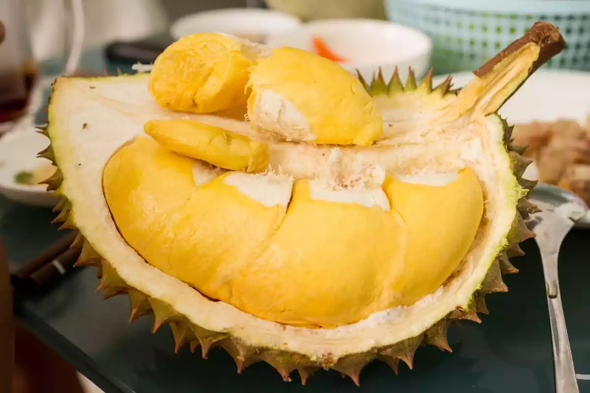 Un durian abierto con la pulpa a la vista sobre una mesa