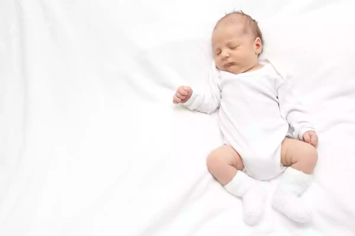 Bebé sobre una sabana blanca