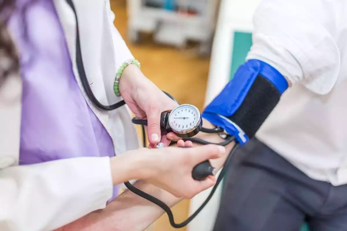 Doctora midiendo la presión arterial de un hombre