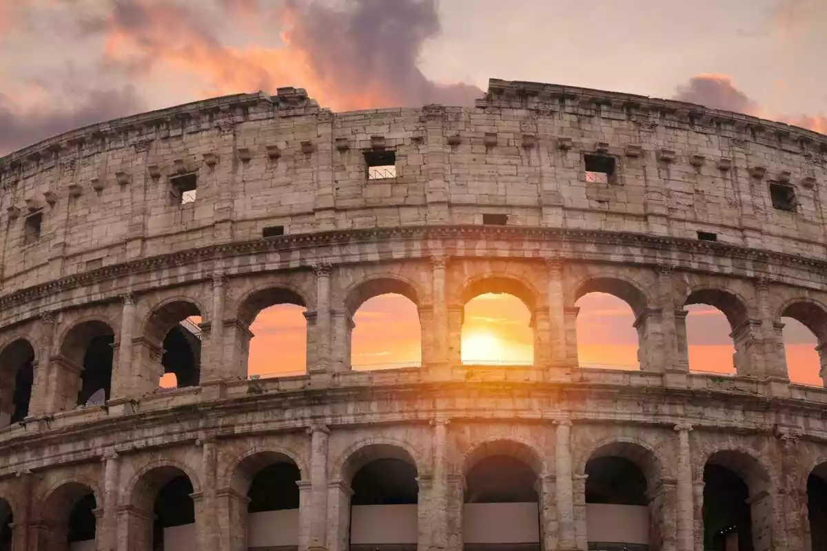 El coliseo romano con la puesta de sol de fondo
