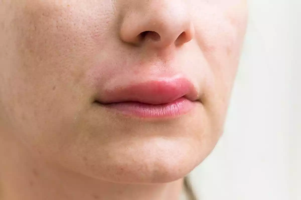 La mitad del rostro de una mujer con los labios enrojecidos