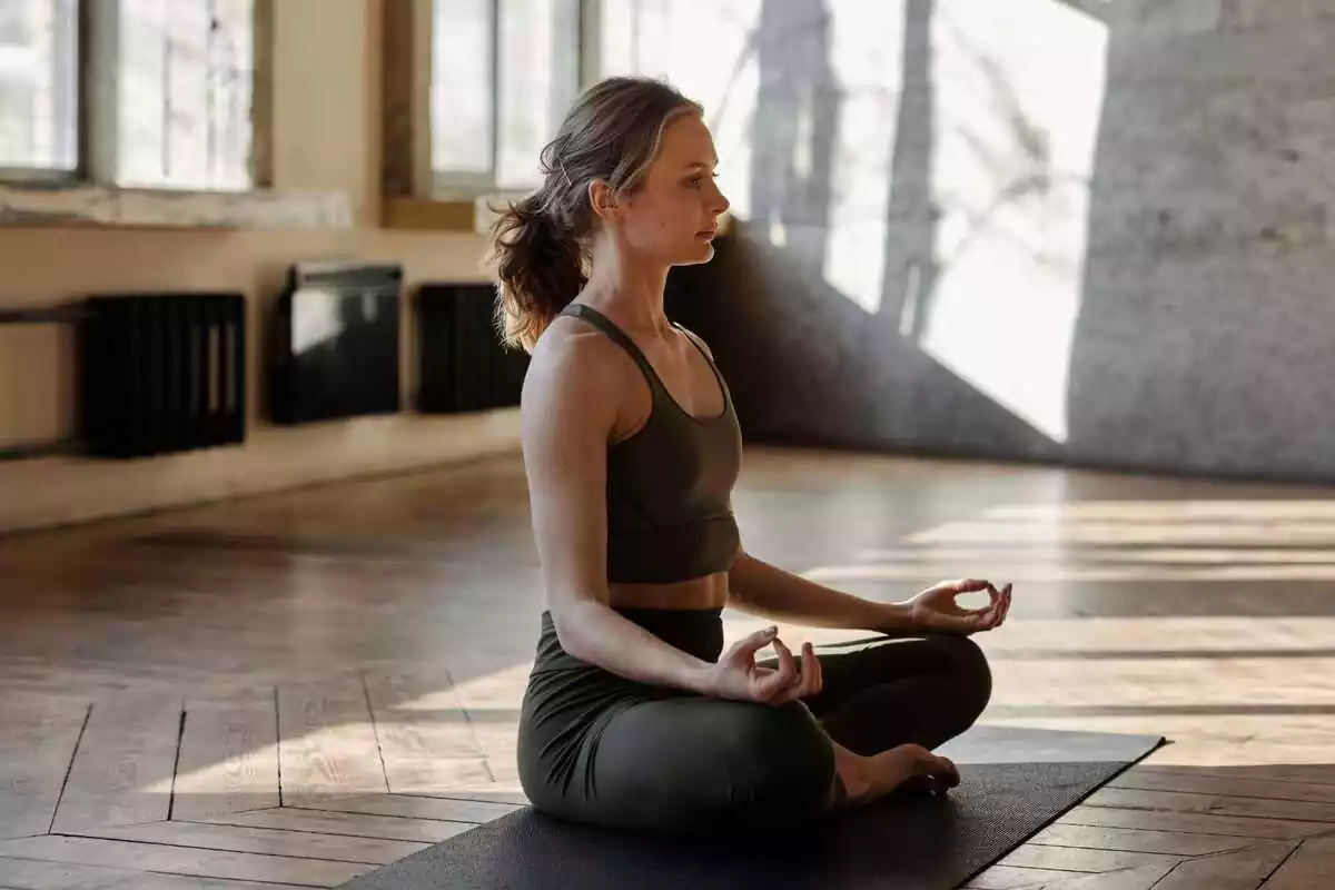 Mujer con las piernas cruzadas haciendo yoga