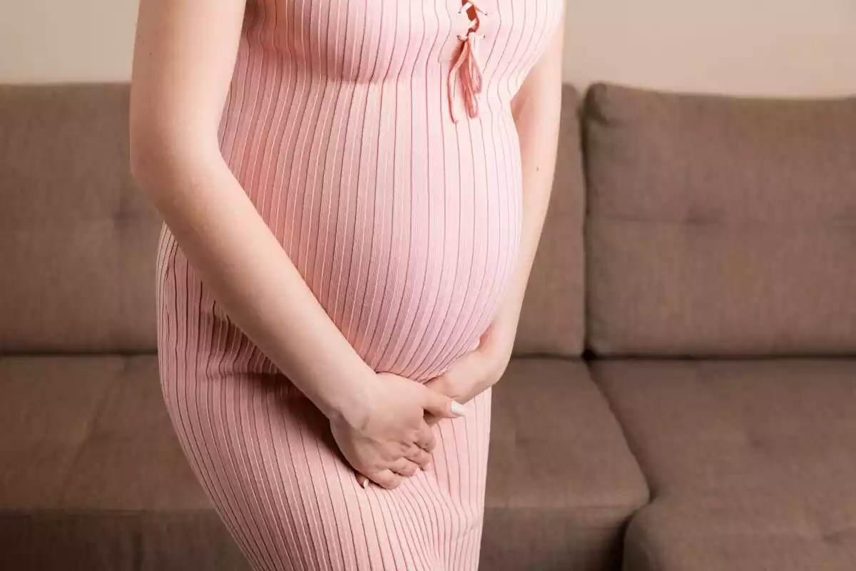 Mujer con vestido rosa embarazada