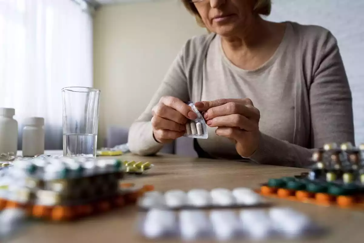 Mujer mayor tomando pastillas