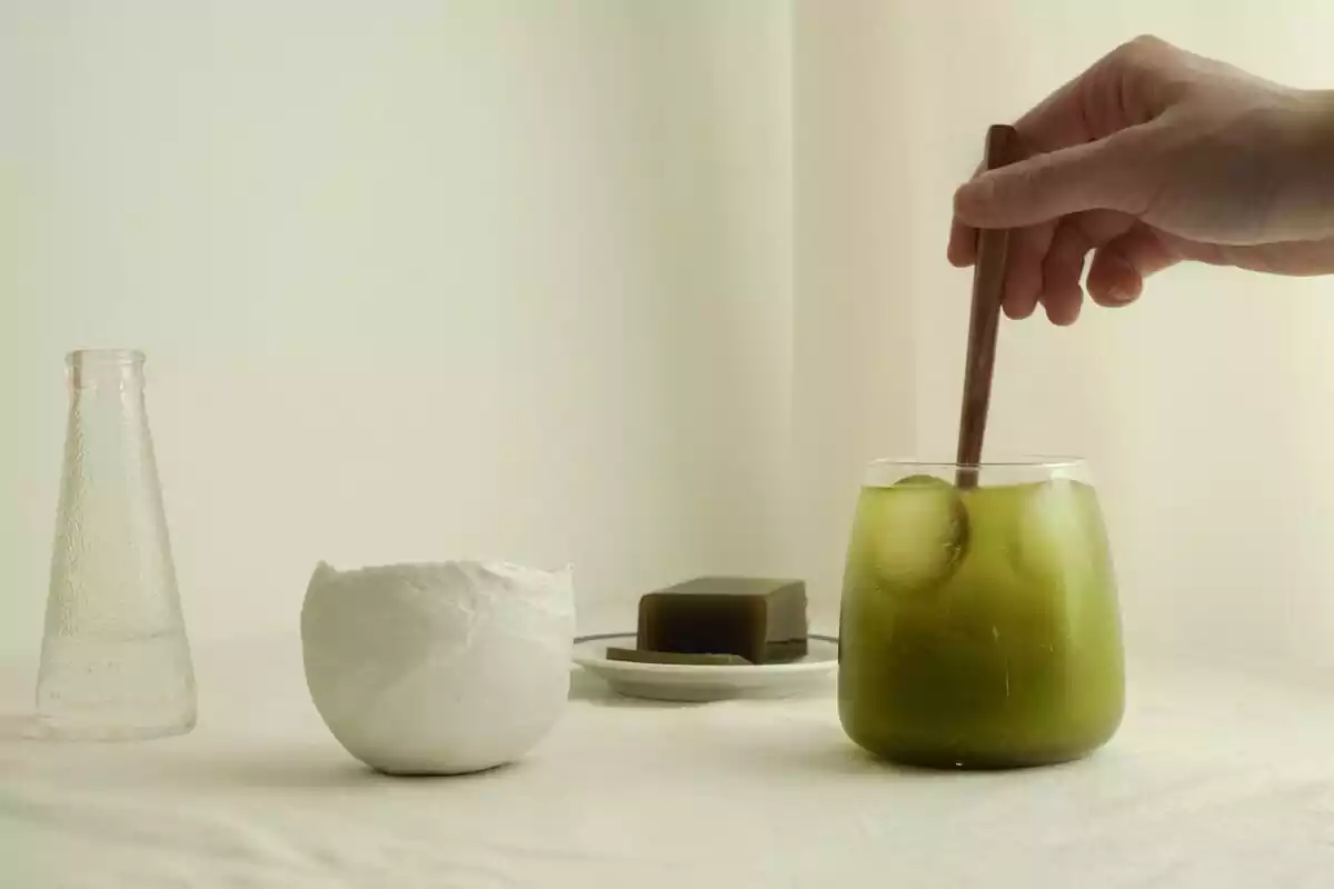Persona removiendo té matcha en un vaso