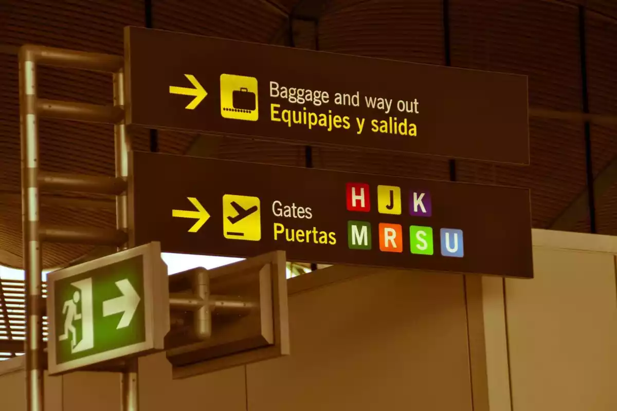 Señales indicativos en un aeropuerto con colores y puertas de embarque