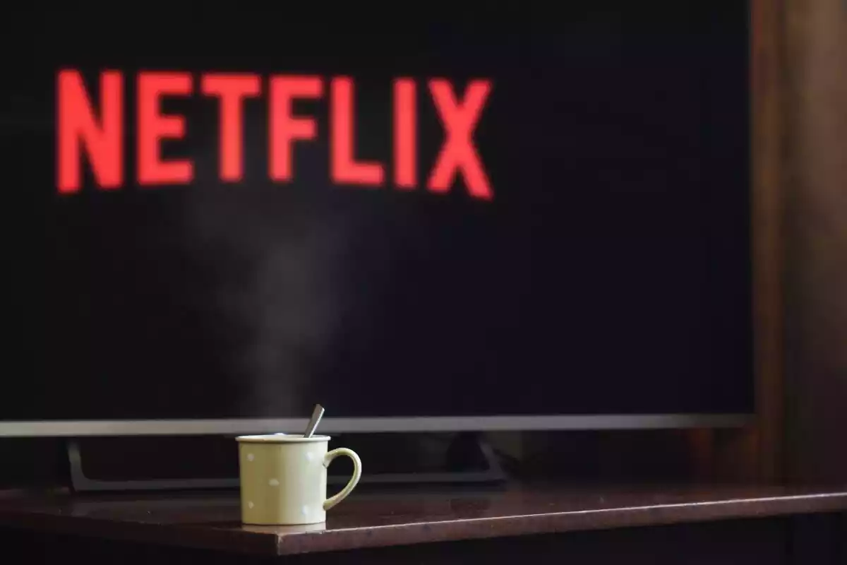 Un televisor con Netflix y una taza justo delante