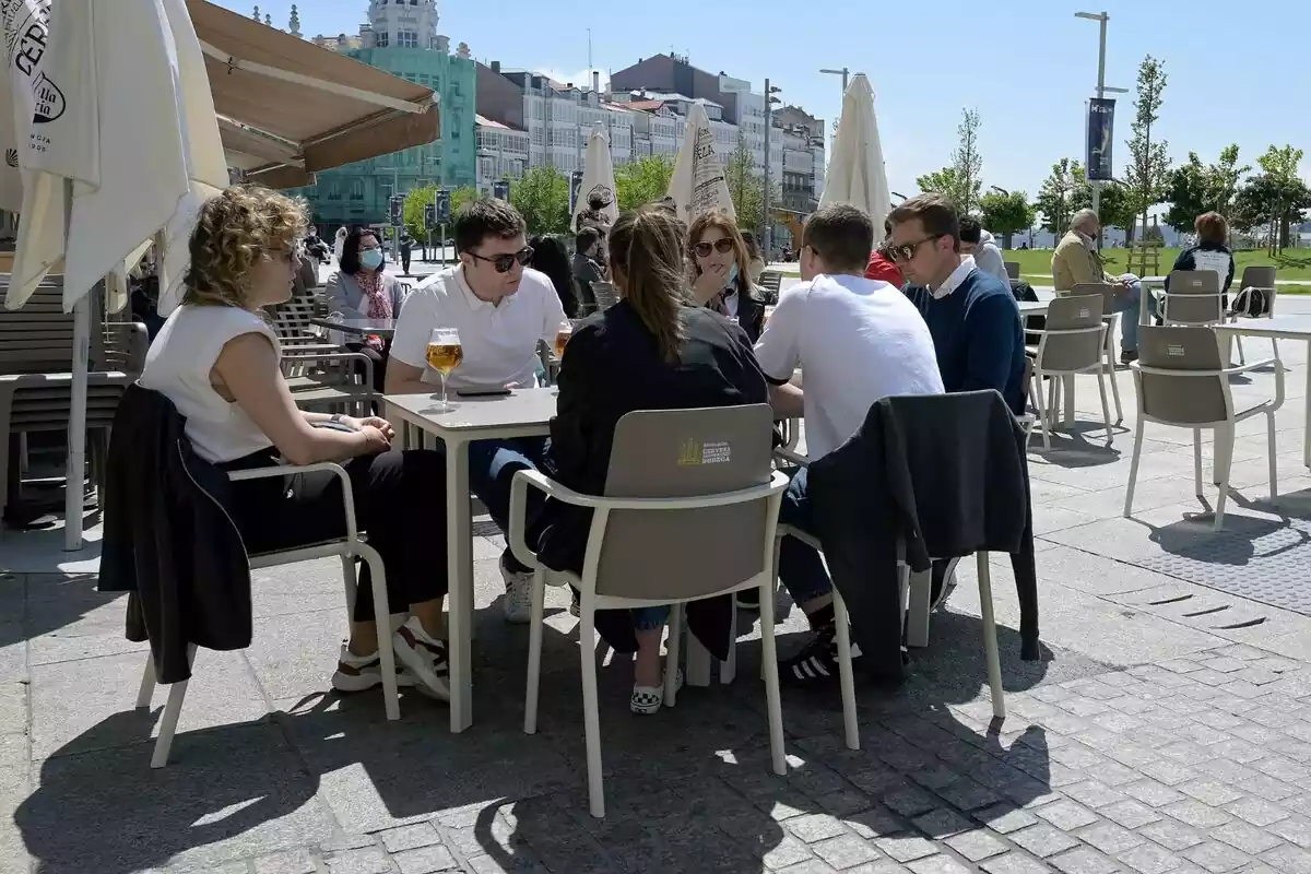 Varias personas tomando una cerveza en una terraza de A Coruña