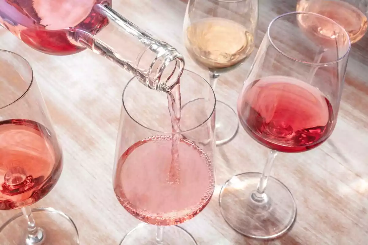 Distintas copas de vino, una de ellas con vino rosa