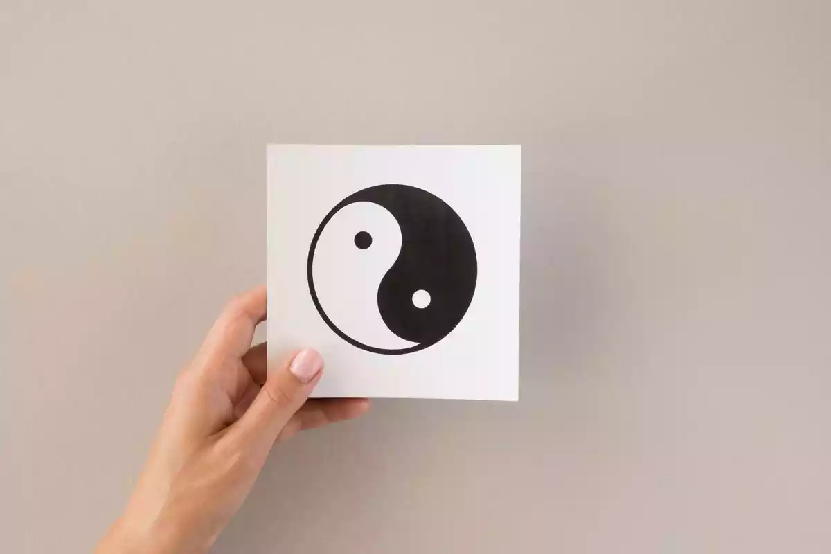 Mano sosteniendo un dibujo del ying yang