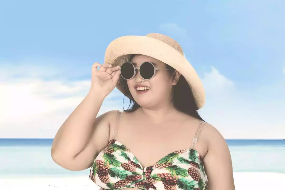 Mujer con un bikini y un sombrero en una playa