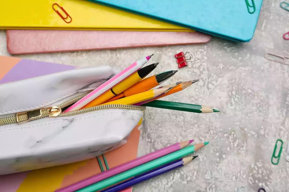 Plano de un estuche con bolígrafos y lápices, rodeador de cartulinas y clips
