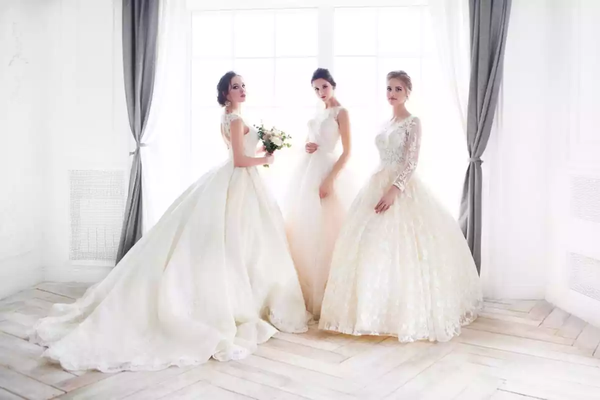 Tres chicas vestidas de novia con vestidos largos