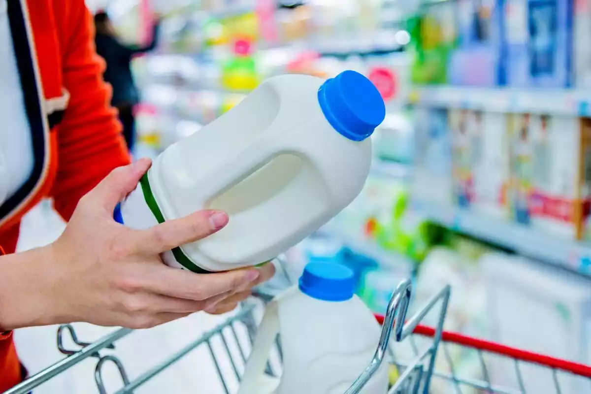 Un hombre comprando leche en un supermercado