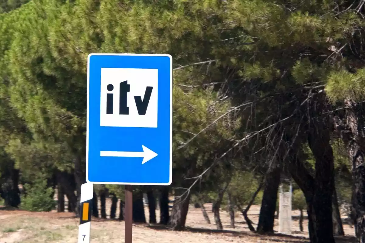 Una señal azul de tráfico indicando con flecha la dirección de la ITV